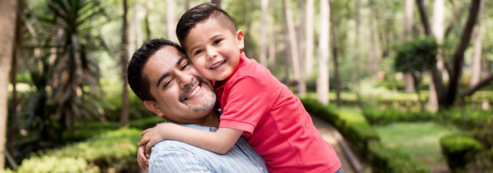 Father holding a child on a park walkway